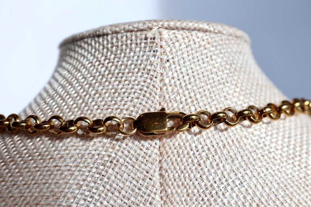Umbra necklace by Auréad Designs resting on a linen bust form, highlighting the gold stainless steel rolo chain and lobster clasp