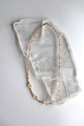 Calora sunstone and citrine necklace laid flat on a raw selenite slab, showing full length with gold-filled lobster clasp